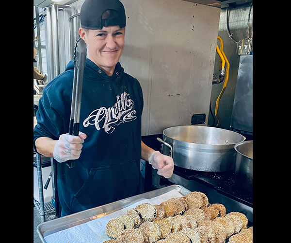 catering staff member holding tongs