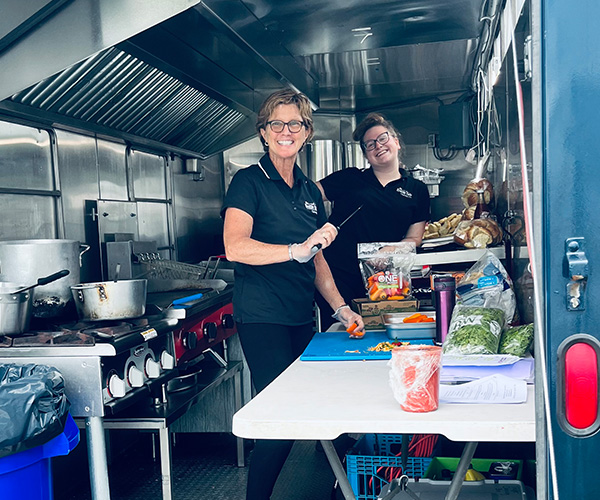 catering staff prepping food inside the Healthy Cafe Catering Co. trailer