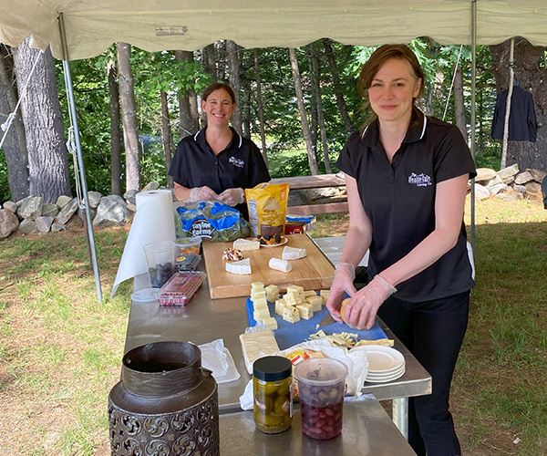 Healthy Cafe Catering staff prepping food under an event tent