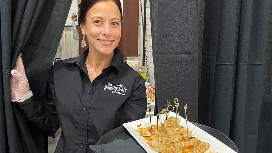 Healthy Cafe Catering Co. staff member holding a plate of appetizers