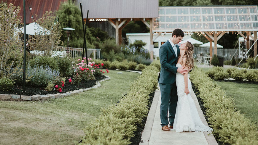 bride and groom in a garden outside a wedding venue